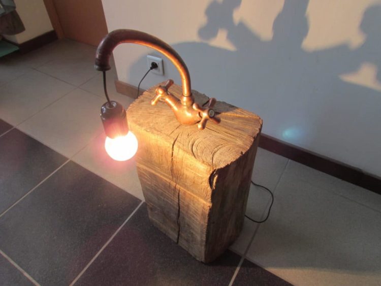 Copper Faucet Lamp on Wood Log